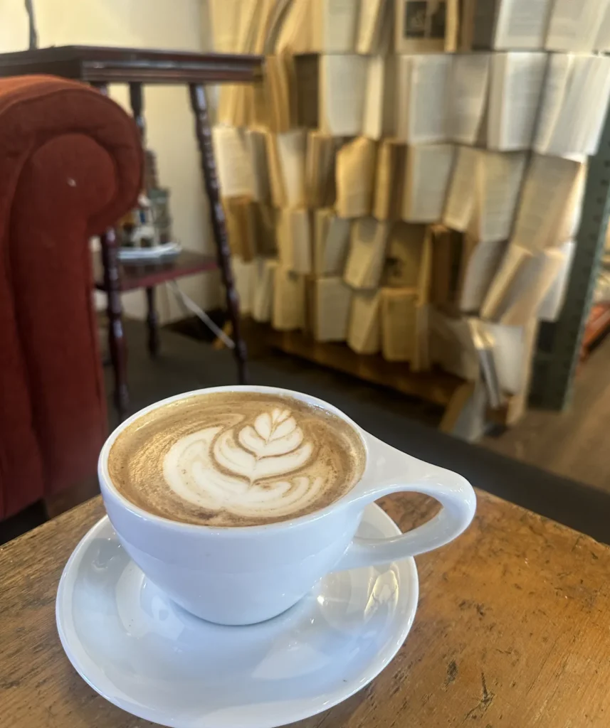 a hot latte from brighton coffeehouse and theatre overlooking a range of books